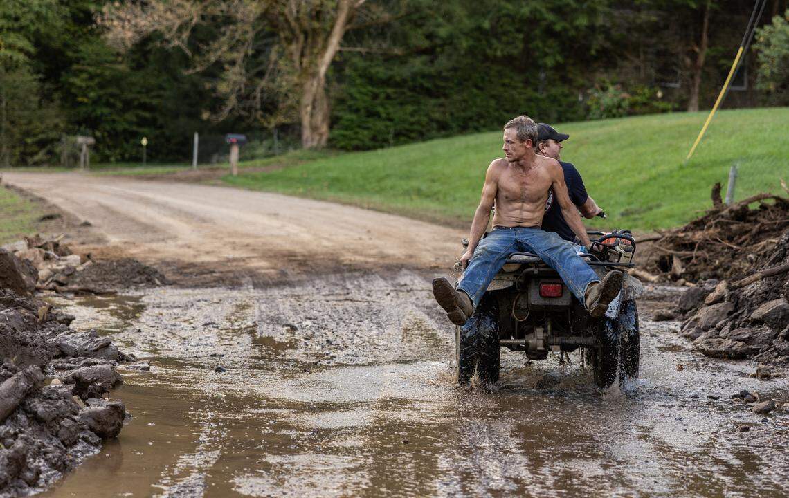 A man rides on the back of a four wheeler in Barnardsville, N.C. on Wednesday, October 2, 2024.