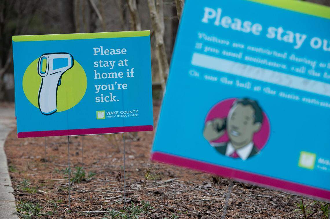 Signage at the entrance to Athens Drive Magnet High School on Wednesday, February 10, 2020 in Raleigh, N.C., alert visitors to temperature checks, social distancing and warnings about staying home if you are sick as they prepare to welcome back students for in-person classes next week.