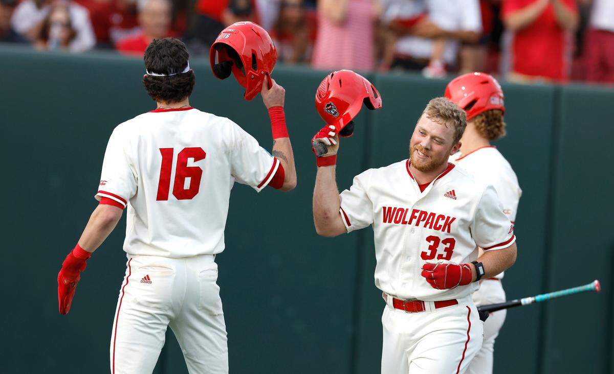 N.C. State’s Garrett Pennington (33) celebrates with Eli Serrano III (16) after Pennington hit a two-run home run in the third inning during N.C. State’s game against South Carolina in the NCAA Raleigh Regional at Doak Field Saturday, June 1, 2024.