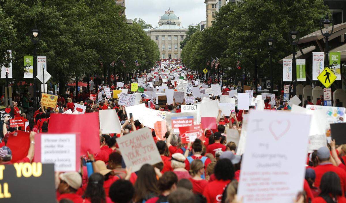 Marchers walk up Fayetteville Street during the March for Students and Rally for Respect on Wednesday, May 16, 2018. North Carolina teachers should see a boost in pay with the new state budget.
