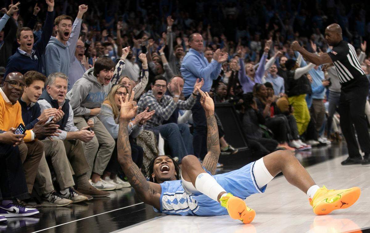 North Carolina’s Caleb Love (2) reacts after sinking a three point basket and drawing a foul to tie the game in the first half against Michigan on Wednesday, December 21, 2022 at the Spectrum Center in Charlotte, N.C. Love scored 18 points in the Tar Heels’ 80-76 victory.