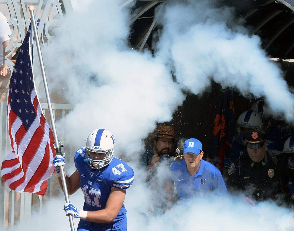 Duke linebacker David Helton leads Coach David Cutcliffe and the rest of the Blue Devils onto the field at Wallace Wade Stadium in Durham, NC Saturday, Sept. 18, 2014 for the Virginia game.