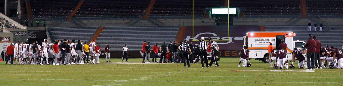 N.C. State and Virginia Tech players watch as medical staff attend to Khalid Martin during the second half of Virginia Tech’s 45-24 victory over N.C. State at Lane Stadium in Blacksburg, VA Saturday, Sept. 26, 2020.