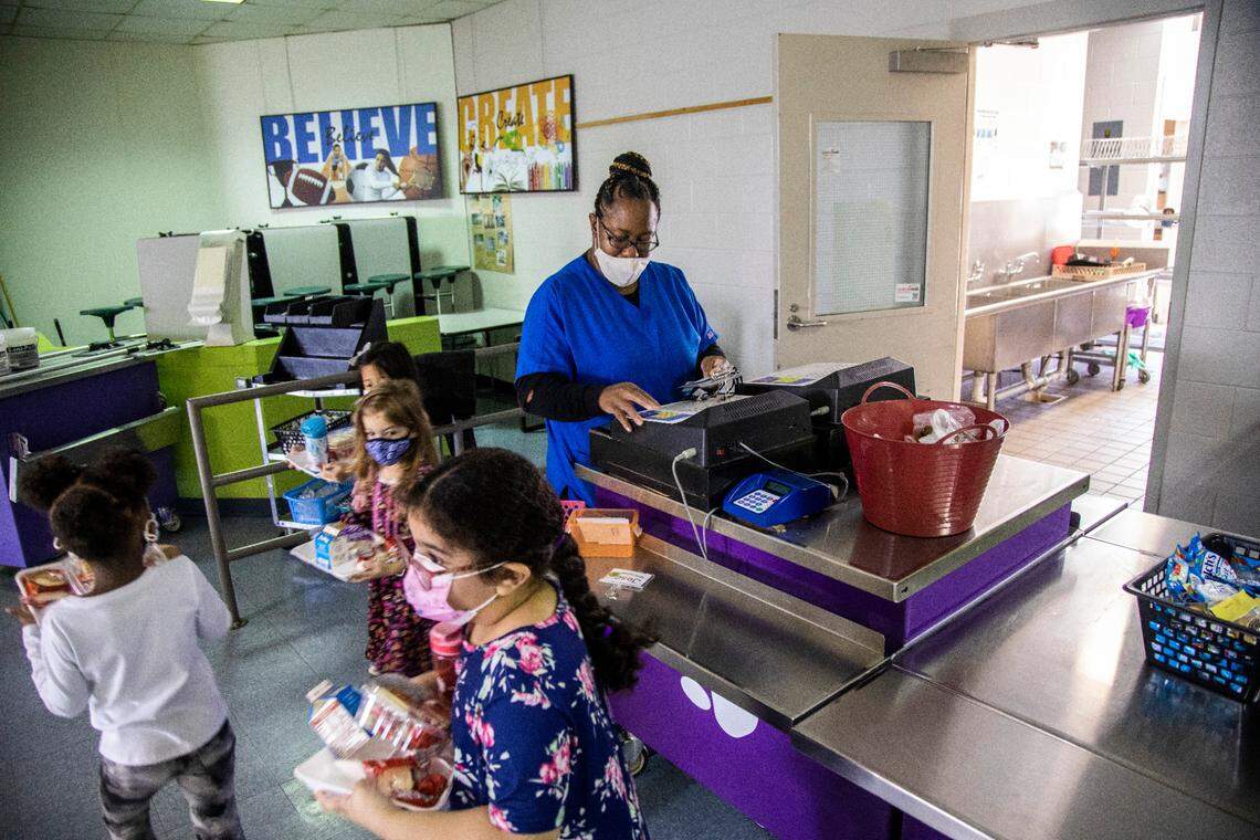 Yolanda Banks serves meals to students at Swift Creek Elementary in Raleigh. The Wake County school system, like others in the state, has a shortage finding enough people to work in school cafeterias.