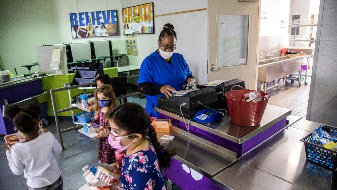 Yolanda Banks serves meals to students at Swift Creek Elementary in Raleigh. The Wake County school system, like others in the state, has a shortage finding enough people to work in school cafeterias.