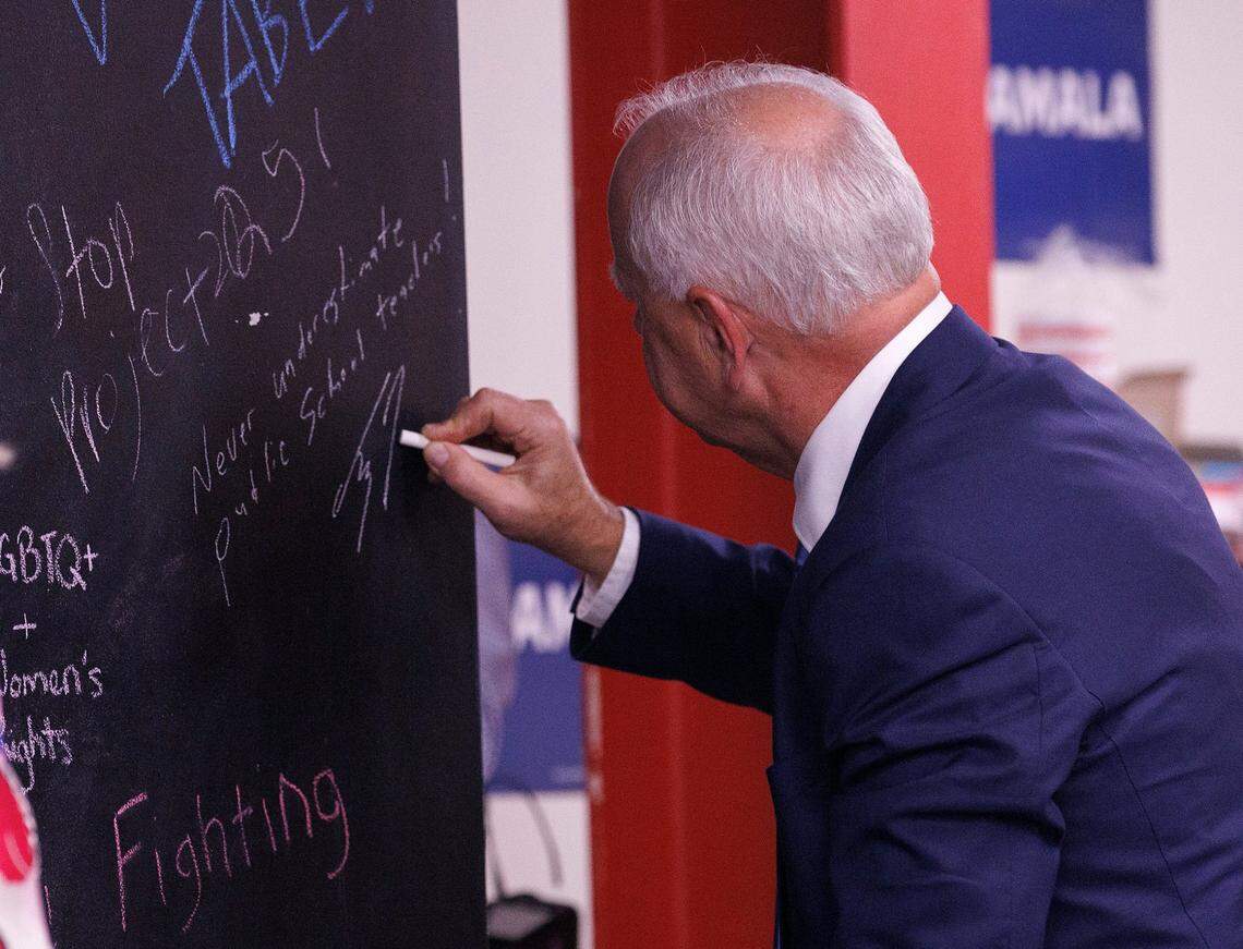 Democratic Vice Presidential nominee and Minnesota Gov. Tim Walz writes a message on a chalkboard during a visit to a campaign office in Raleigh, N.C. on Thursday, Aug. 29, 2024.