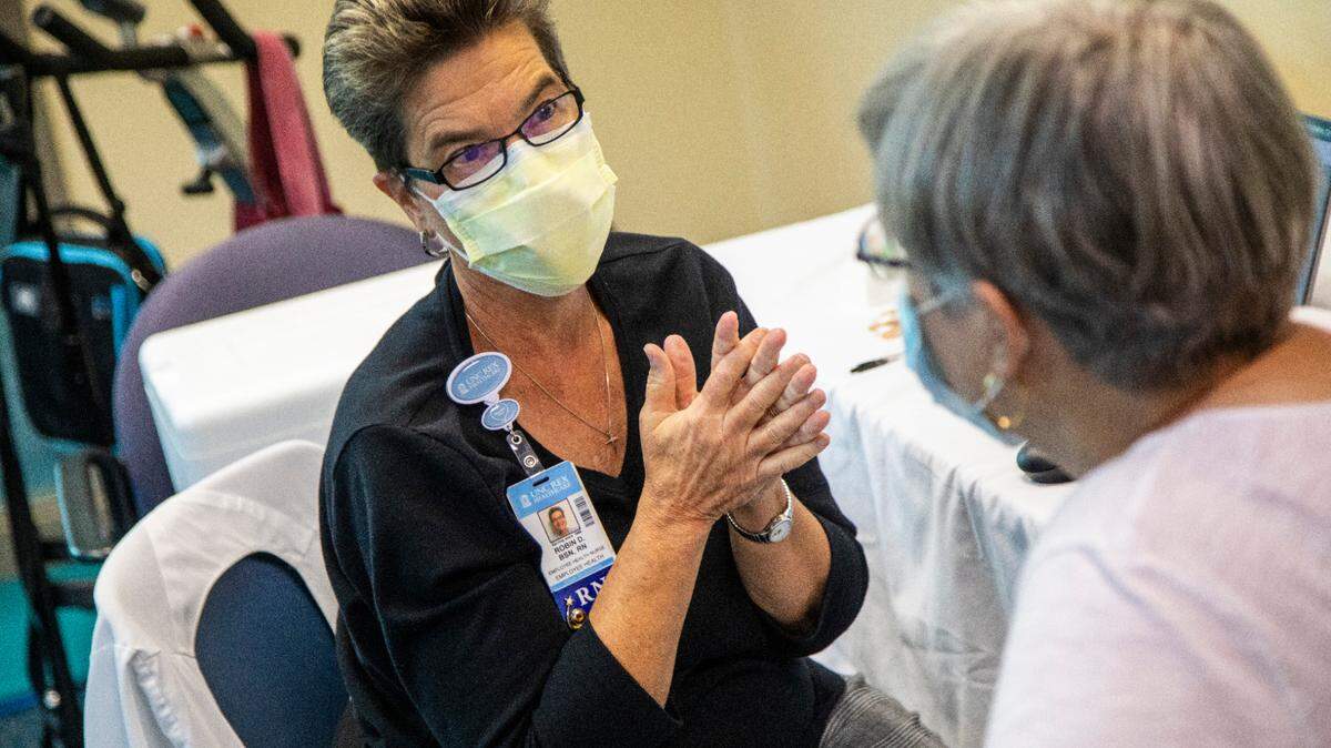 Robin Deal, a retired registered nurse, left, prepares to administer a flu shot to Susan Grant at Rex Wellness Center of Cary on Thursday, Oct. 14, 2021. By giving flu shots this fall, Deal is helping other Rex nurses respond to the COVID-19 pandemic.