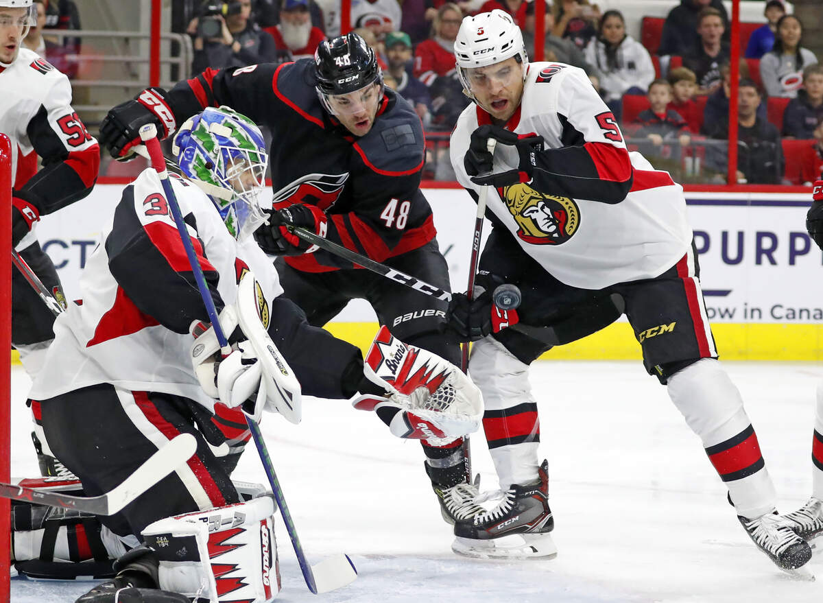Carolina Hurricanes’ Jordan Martinook (48) works between Ottawa Senators goaltender Anders Nilsson (31) and Senators’ Cody Ceci (5) during the first period of an NHL hockey game Friday, Jan. 18, 2019, in Raleigh, N.C. (AP Photo/Karl B DeBlaker)