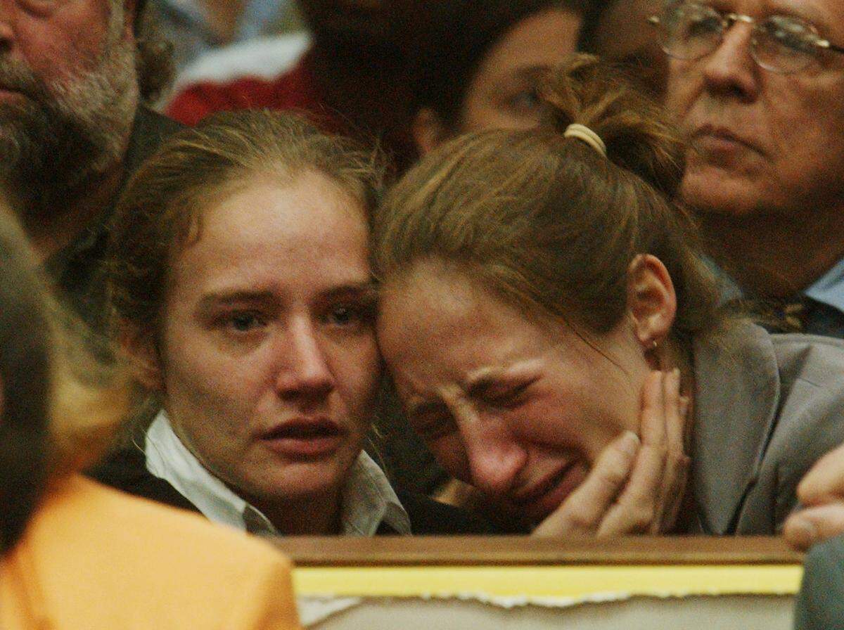 Martha Peterson (at left) attempts to comfort her sister Margaret after their guardian Michael Peterson is found guilty of first degree murder in the death of his wife Kathleen Peterson. He was sentenced to life in prison.