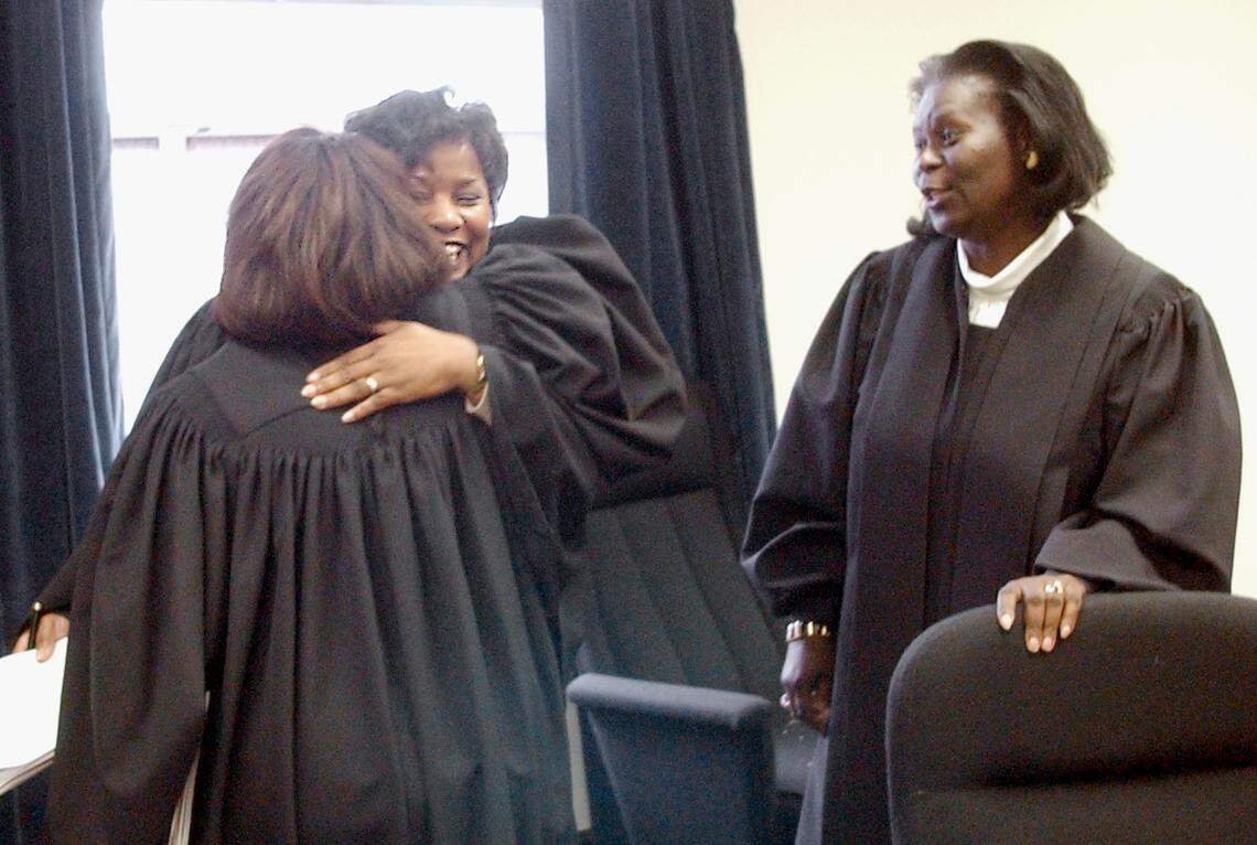 NC Court of Appeals judges Wanda Bryant, left, and Loretta Biggs hug after hearing a case in 2002. Justice Patricia Timmons-Goodson looks on at right. It was the first time in state history that three black women heard an appeals case.