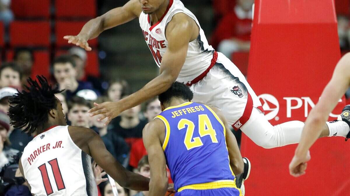 N.C. State’s Dennis Parker Jr. and Casey Morsell defend against Pittsburgh’s William Jeffress during the first half of the Wolfpack’s game on Wednesday, Feb. 7, 2024, at PNC Arena in Raleigh, N.C.