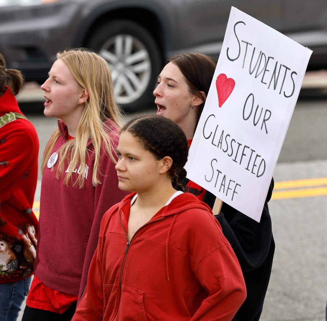 Jordan High School seniors, clockwise from left, Angie Bean-Ross, Avari Clark and Emma Fisher march around the Durham Public Schools administrative building during a protest in Durham, N.C., Wednesday, Jan. 31, 2024. Twelve Durham public schools were closed Wednesday as staff — furious about unresolved salary issues — called in sick to attend protests.