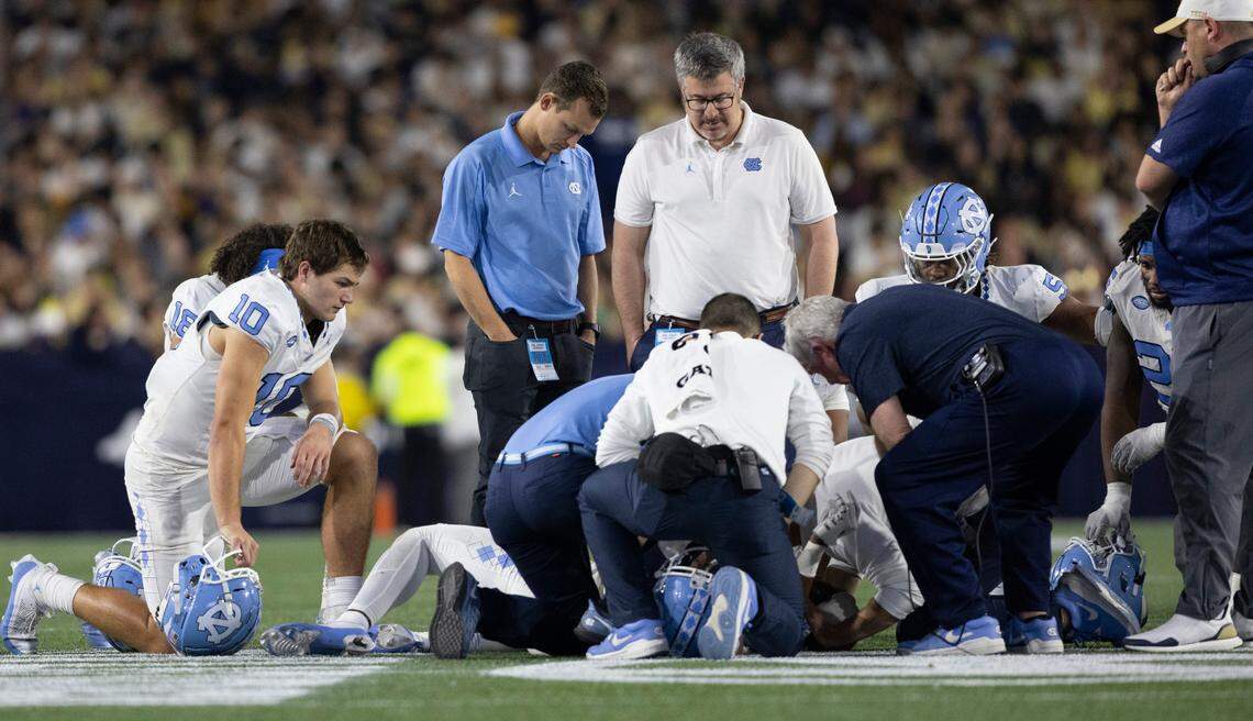 North Carolina quarterback Drake Maye takes a knee as coach Mack Brown and medical personnel check on Devontez Walker (9) who was injured by Georgia Tech’s Kyle Efford (44) and Ahmari Harvey (18) in the fourth quarter on Saturday, October 28, 2023 at Bobby Dodd Stadium in Atlanta, Georgia.
