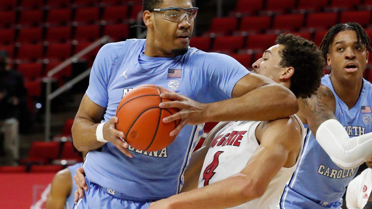 North Carolina’s Garrison Brooks (15) is called for the offensive foul on N.C. State’s Jericole Hellems (4) during the first half of N.C. State’s game against UNC at PNC Arena in Raleigh, N.C., Tuesday, December 22, 2020.