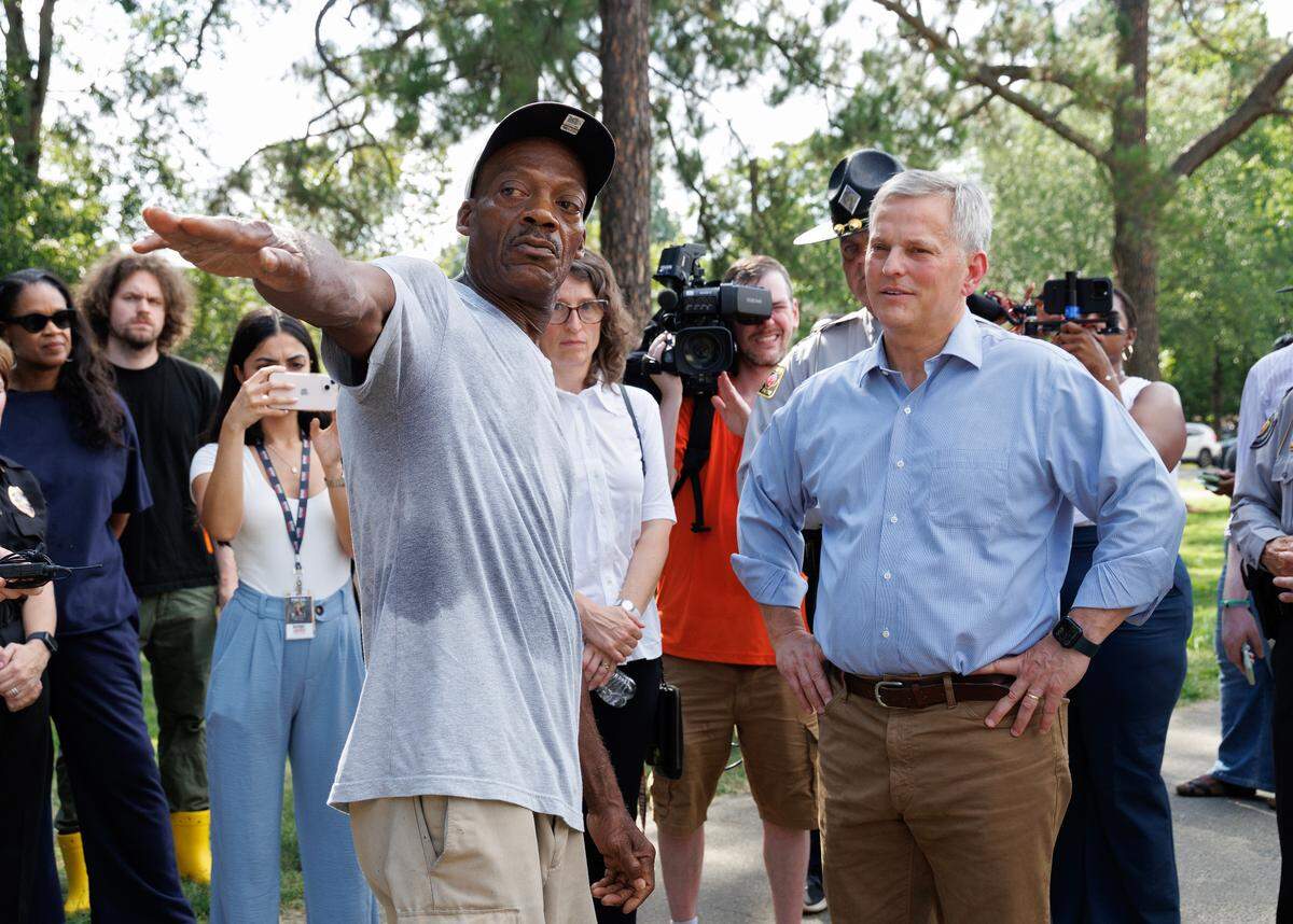 Camelot Village resident Shelton Stokes describes his experience escaping floodwaters from remnants of Tropical Storm Chantal as Gov. Josh Stein listens during a tour of the apartment complex on Friday, July 18, 2025, in Chapel Hill, N.C.