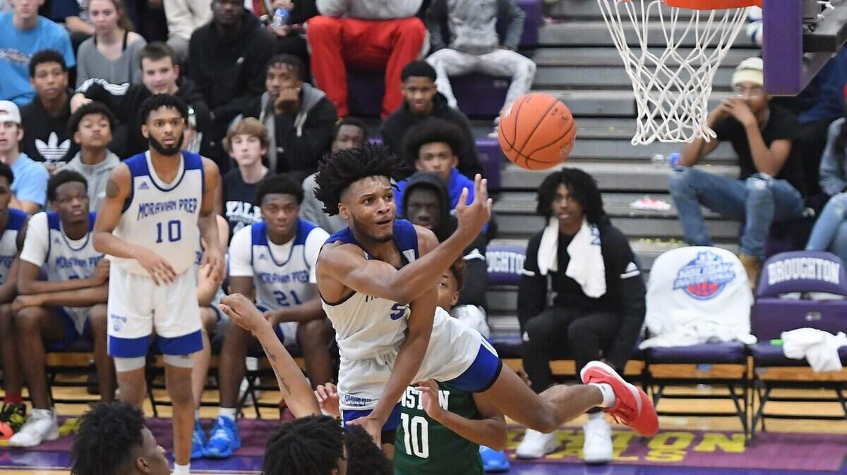 Josh Hall (5) of Moravian Prep drives to the basket against Jaquan Mosley (10) of Kinston. The Moravian Prep Lions played the Kinston Vikings in a boys basketball game that was part of the John Wall Holiday Invitational on December 26, 2019.