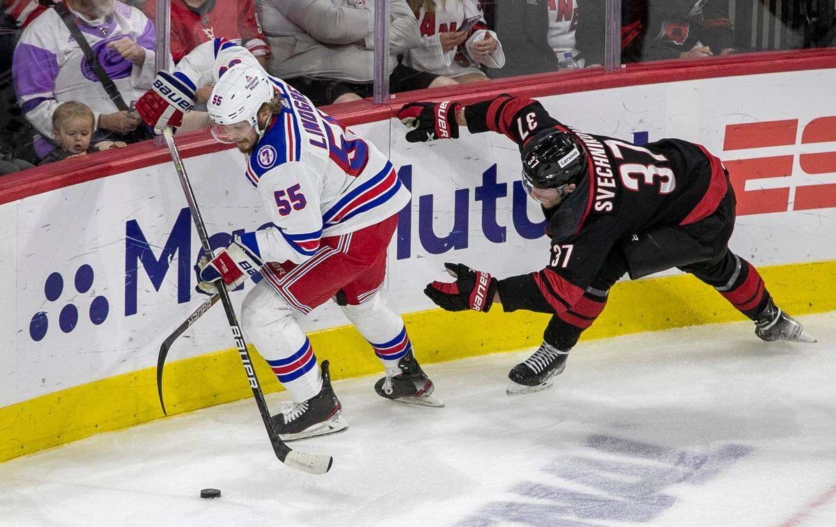 Carolina Hurricanes Andrei Svechnikov (37) loses his stick as he battles for the puck with New York Rangers Ryan Lindgren (55) in the first period on Friday, May 20, 2022 during game two of the Stanley Cup second round at PNC Arena in Raleigh, N.C