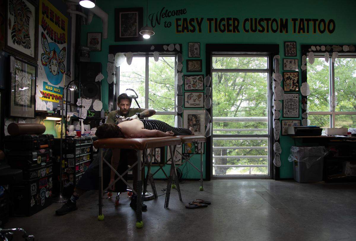 Mike Wheeler, owner of Easy Tiger Custom Tattoo in Durham, tattoos Erin Barringer on Wednesday, June 21, 2023.