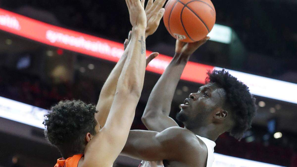 N.C. State’s Ebenezer Dowuona (21) shoots as Virginia Tech’s Keve Aluma (22) defends during the second half of Virginia Tech’s 62-59 victory over N.C. State at PNC Arena in Raleigh, N.C., Wednesday, Jan. 19, 2022.
