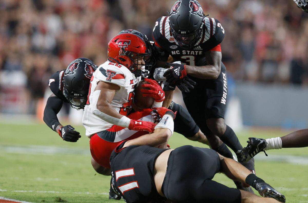 N.C. State linebacker Payton Wilson (11), safety Cyrus Fagan (4) and cornerback Aydan White (3) tackle Texas Tech wide receiver Nehemiah Martinez (20) during the first half of N.C. States game against Texas Tech at Carter-Finley Stadium in Raleigh, N.C., Saturday, Sept. 17, 2022.