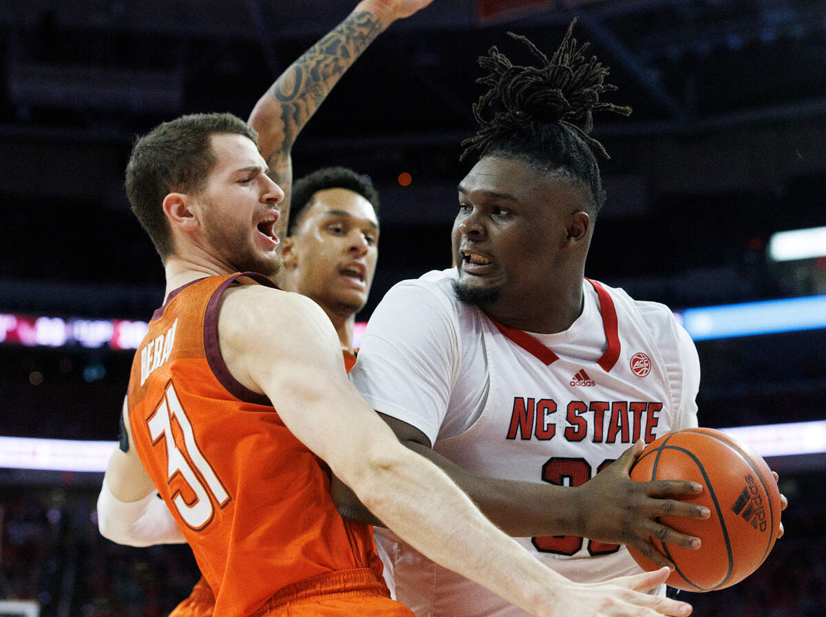 N.C. State’s DJ Burns Jr. looks to pass around Virginia Tech’s Robbie Beran and Lynn Kidd during the first half of the Wolfpack’s game on Saturday, Jan. 20, 2024, at PNC Arena in Raleigh, N.C.