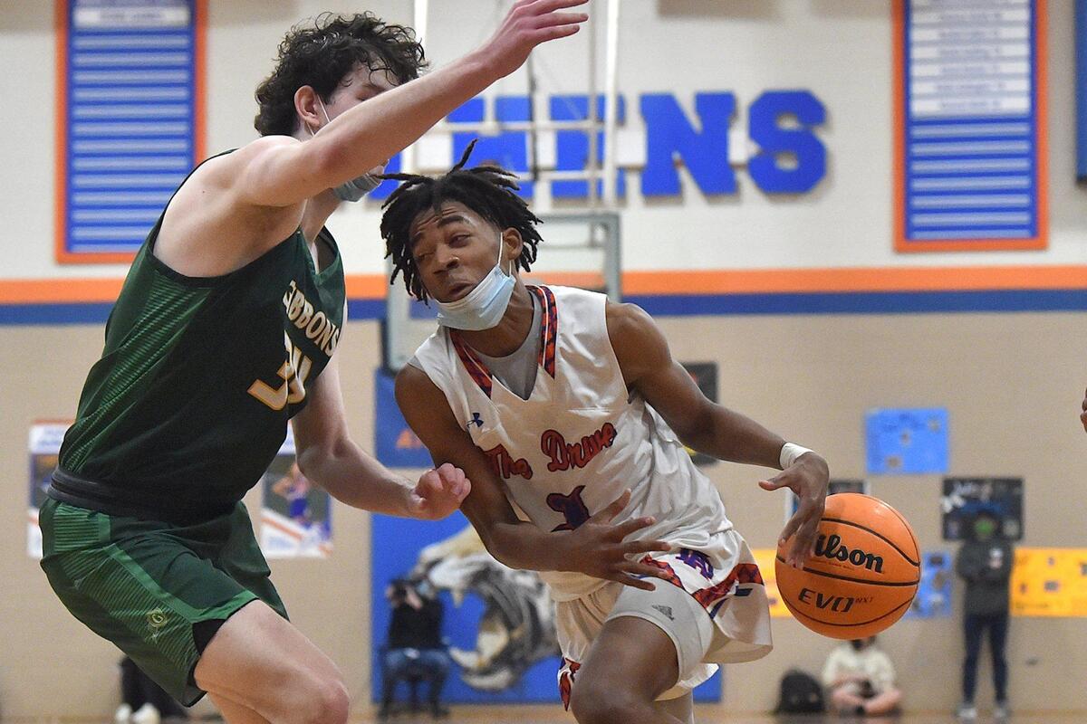 Athens Drive’s Dynaven Lyons (1) loses control of the ball against Cardinal Gibbons’ Matthew Field (34) during the second quarter. The Athens Drive Jaguars and the Cardinal Gibbons Crusaders met in a basketball game in Raleigh, N.C. on February 11, 2022.
