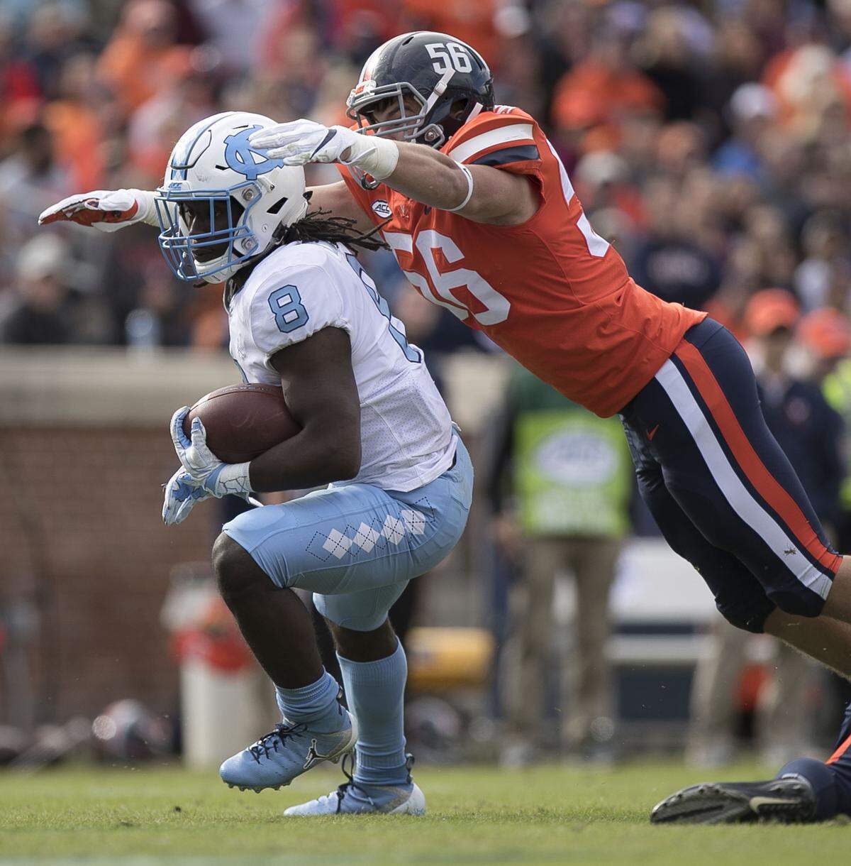 Virginia’s Matt Gahm (56) stops North Carolina’s Michael Carter (8) after a gain of ten yards to set up the Tar Heels’ only touchdown of the second half in their 31-21 loss to Virginia on Saturday, October 27, 2018 at Scott Stadium in Charlottesville, Va.