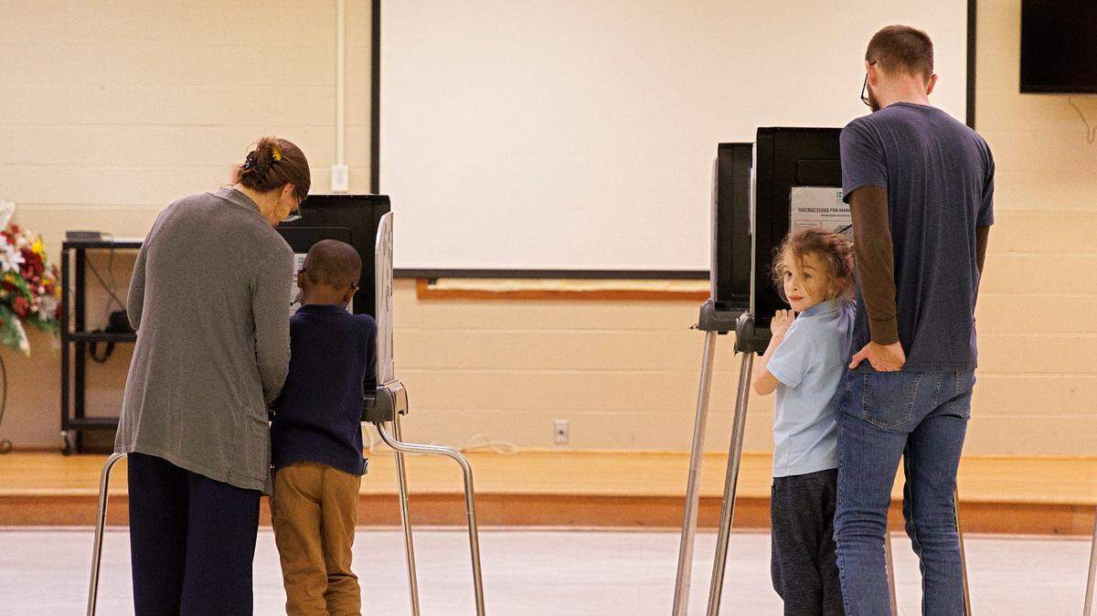 Laura Klein and Andrew Witkins vote with their children, Prince, 6, and Otis, 8, at White Rock Baptist Church on Tuesday, March 5, 2024, in Durham, N.C.