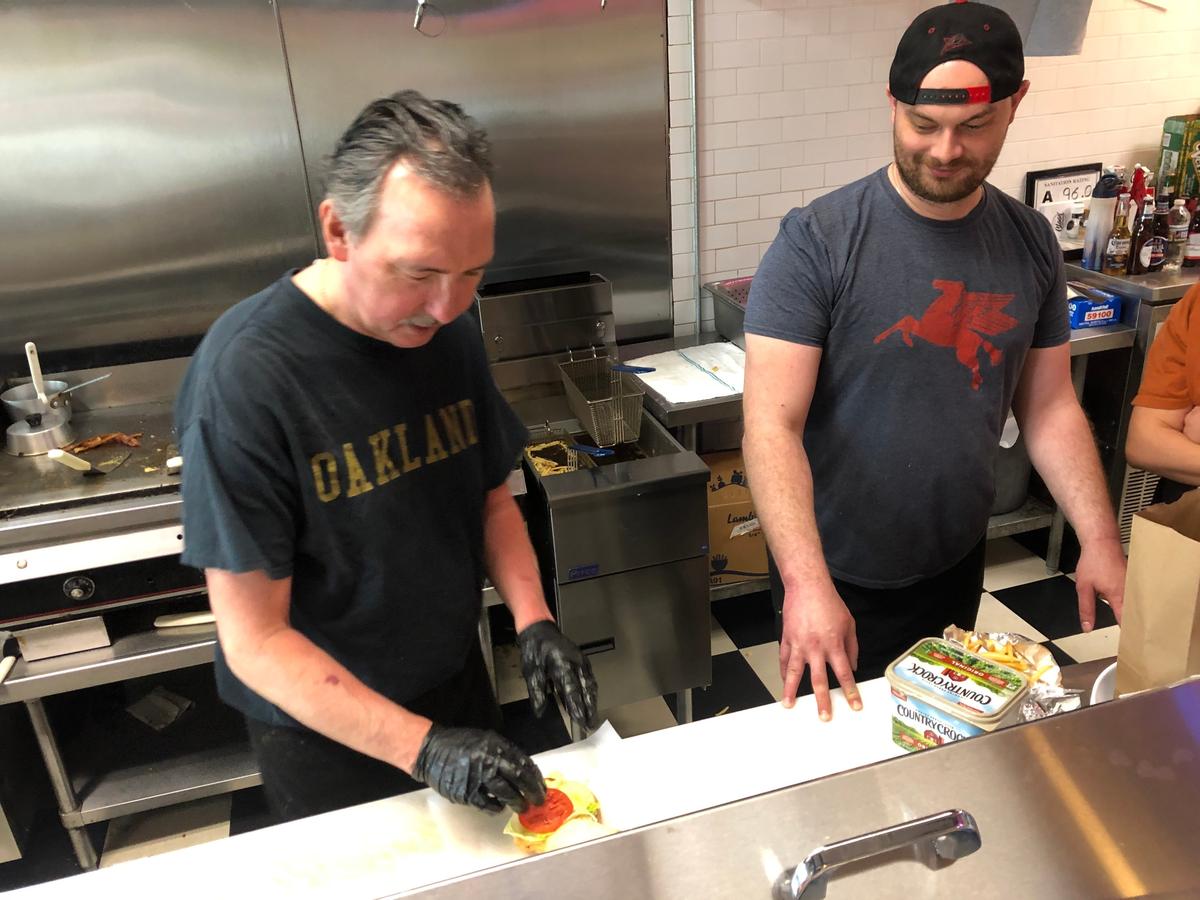 Dan Cloos (left) and his son Mark prepare orders at Cloos’ Coney Island on Friday.