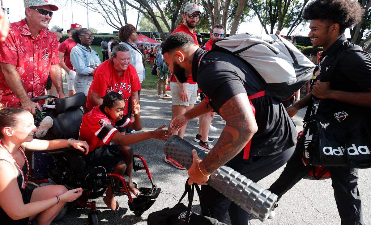 N.C. State’s Davin Vann and KC Concepcion greet Grayson Ketchie during the Walk of Champions before N.C. State’s game against Western Carolina at Carter-Finley Stadium in Raleigh, N.C., Thursday, August 29, 2024.