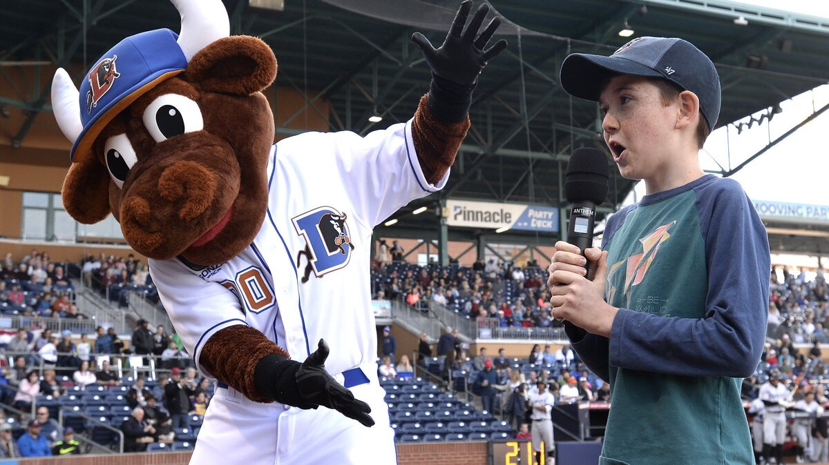 Silas Lean (right) yells, “Play ball!” with a little help from Wool E. Bull as he officially starts the 2018 season for the Durham Bulls during opening day Thursday, April 5, 2018 in Durham, N.C.