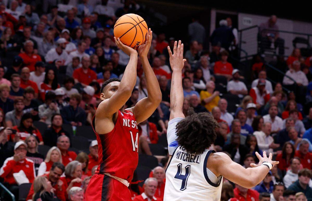 N.C. State’s Casey Morsell (14) shoots a three-pointer as Marquette’s Stevie Mitchell (4) defends during the second half of N.C. State’s 67-58 victory over Marquette in their NCAA Tournament Sweet 16 game at the American Airlines Center in Dallas, Texas, Friday, March 29, 2024.