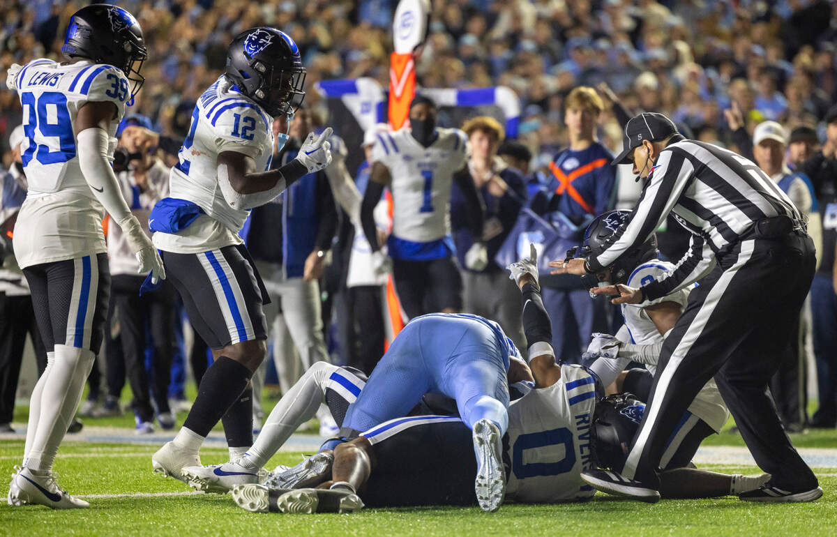 Duke’s Chandler Rivers (0) signals from the bottom of the pile that the Blue Devils have possession of the ball, after a pass reception by North Carolina’s Bryson Nesbit (18) in the fourth quarter on Saturday, Nov. 11, 2023 at Kenan Stadium in Chapel Hill, N.C.