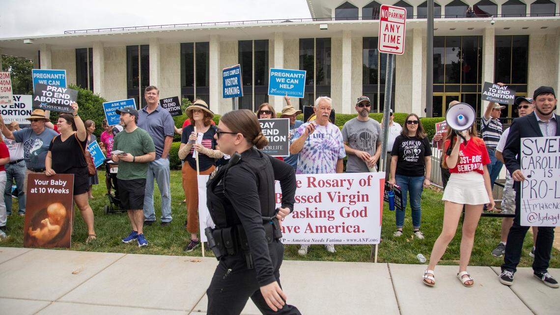 Protesters for and against abortion stake out opposite positions, opposite locations