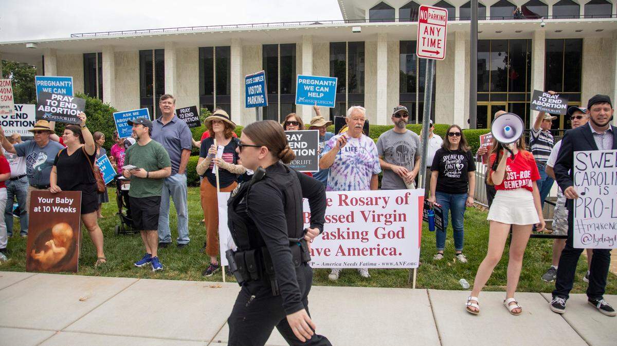 Protesters for and against abortion stake out opposite positions, opposite locations