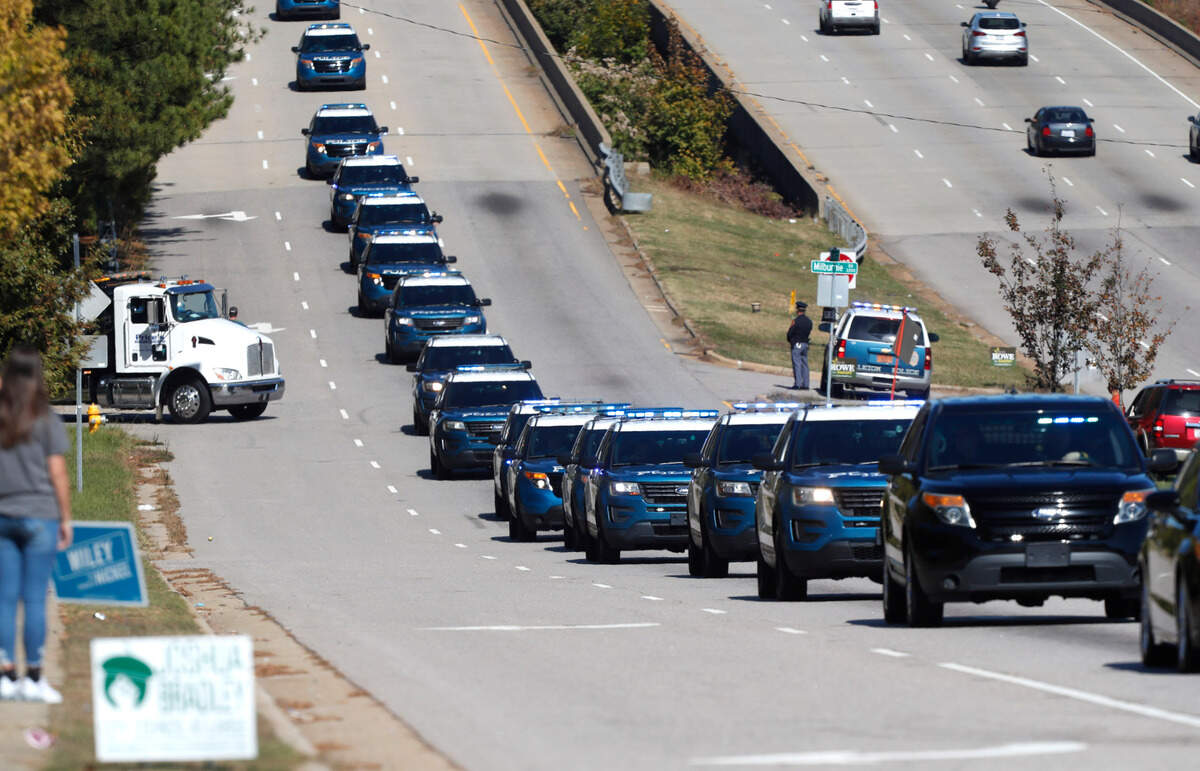 A funeral procession for Raleigh Police Officer Gabriel Torres heads down New Bern Ave. while on its way to Brown-Wynne funeral home in Raleigh Saturday, Oct. 22, 2022. Officer Torres was killed in a mass shooting Oct. 13