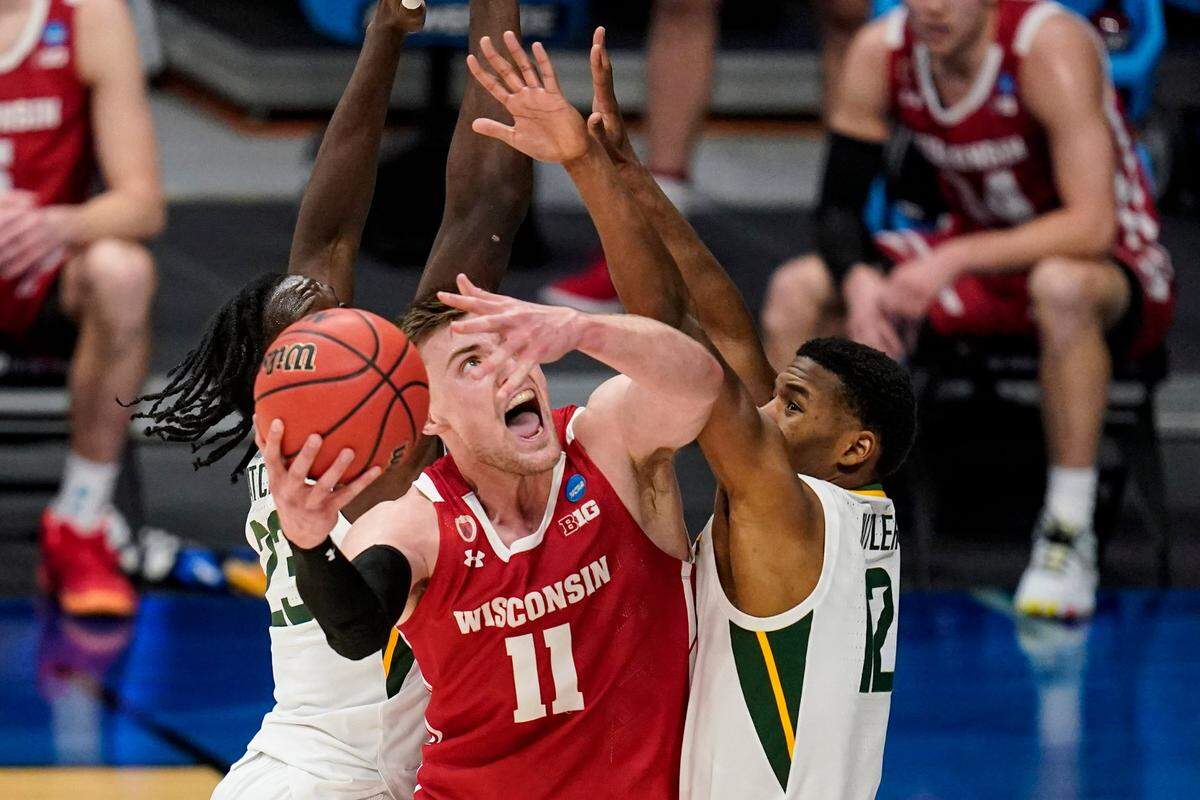 Wisconsin forward Micah Potter (11) shoots around Baylor guard Jared Butler (12) in the second half of a second-round game in the NCAA men’s college basketball tournament at Hinkle Fieldhouse in Indianapolis, Sunday, March 21, 2021. 