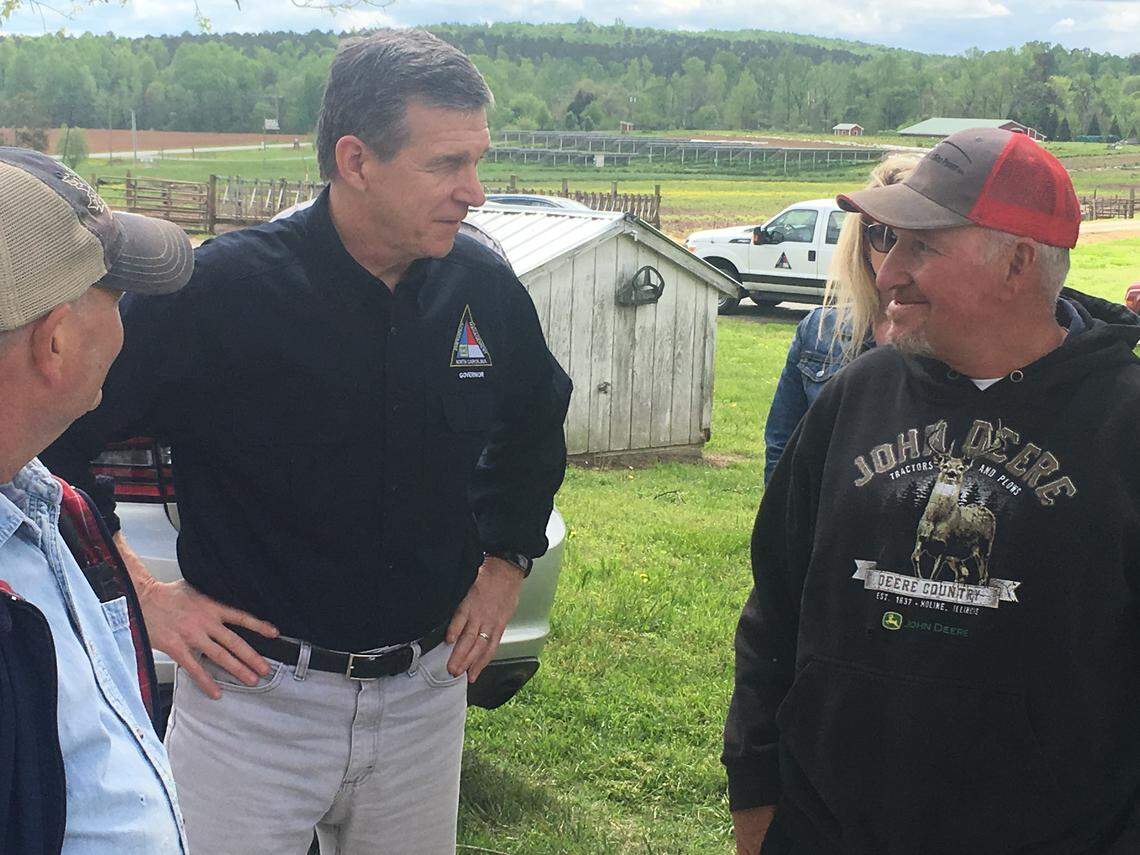 Bob Jackson, herd manager at Maple View Farm in Hillsborough, shows Gov. Roy Cooper damage from Friday’s storm, which damaged two barns and wounded a cow.