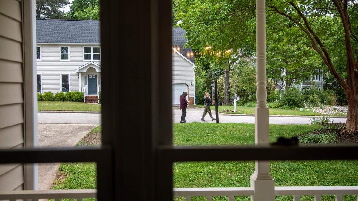 First-time home buyers Carolina Acuipil, left, and Carolina Rancano walk along the front yard of a home for sale in Cary on Thursday, April 27, 2023. Many buyers are spending more of their household incomes on buying a home today, report found.