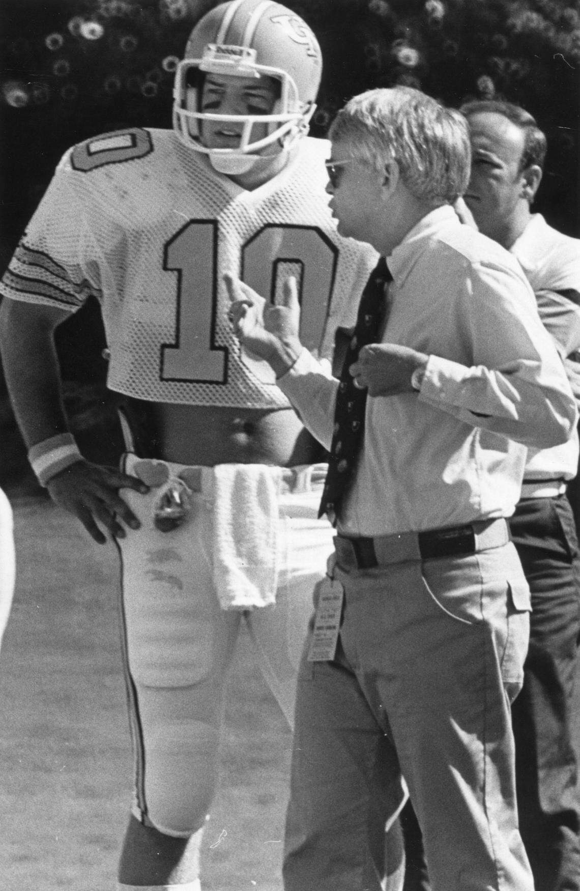 Dick Crum gives the word to quarterback Rod Elkins (10) during the game with N.C. State in 1981.