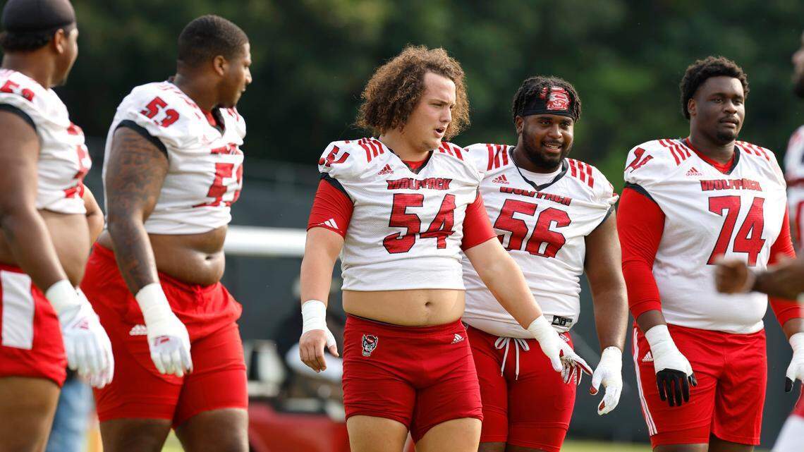 The N.C. State offensive line, from left, Timothy McKay (52), Derrick Eason (53), Dylan McMahon (54), Lyndon Cooper (56) and Anthony Belton (74) prepare to run a drill during the Wolfpack’s first fall practice in Raleigh, N.C., Wednesday, August 2, 2023.
