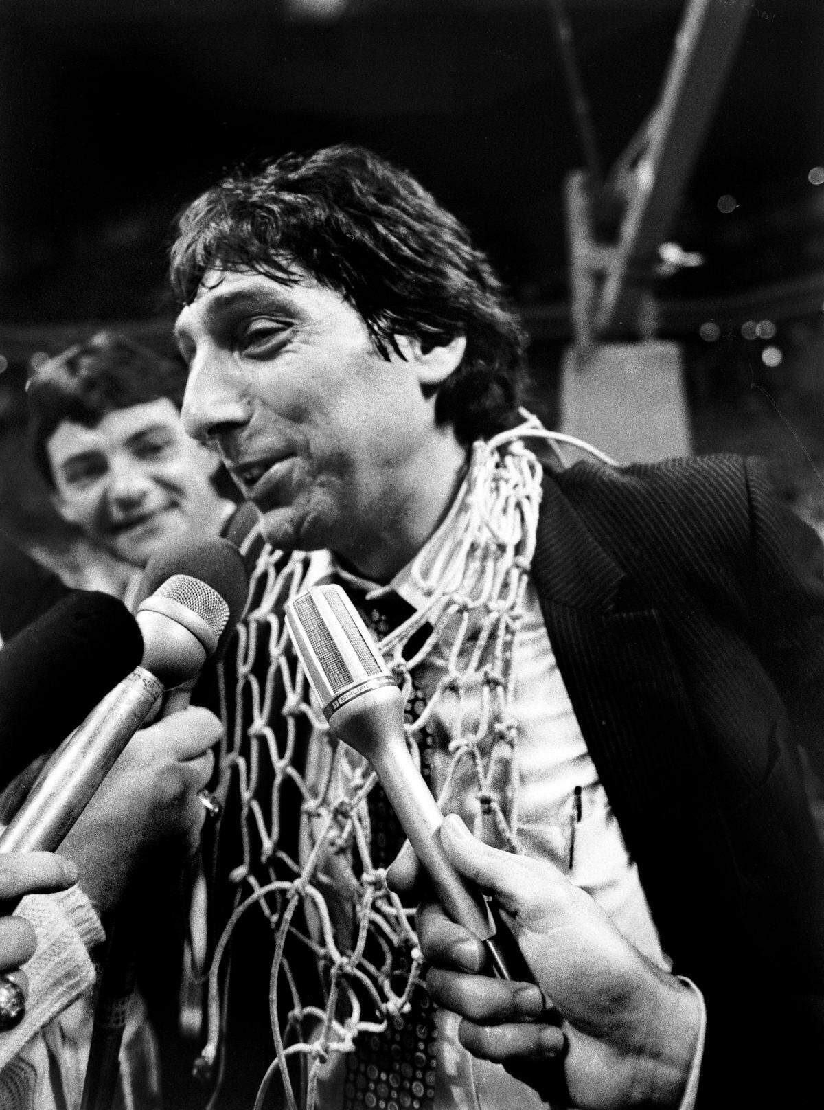 NC State coach Jim Valvano, wearing one of the game nets,  is interviewed following the Wolfpack's 1983 ACC Tournament championship game victory.