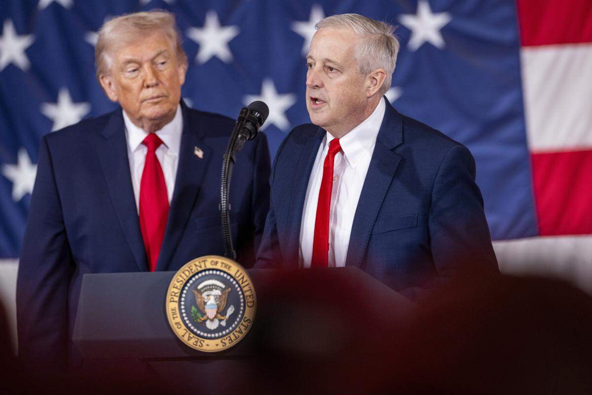 Republican U.S. Senate primary candidate Michael Whatley, right, who is endorsed by President Donald Trump, speaks alongside the president to soldiers from the XVIII Airborne Corps at Fort Bragg in Fayetteville Friday, Feb. 13, 2026.