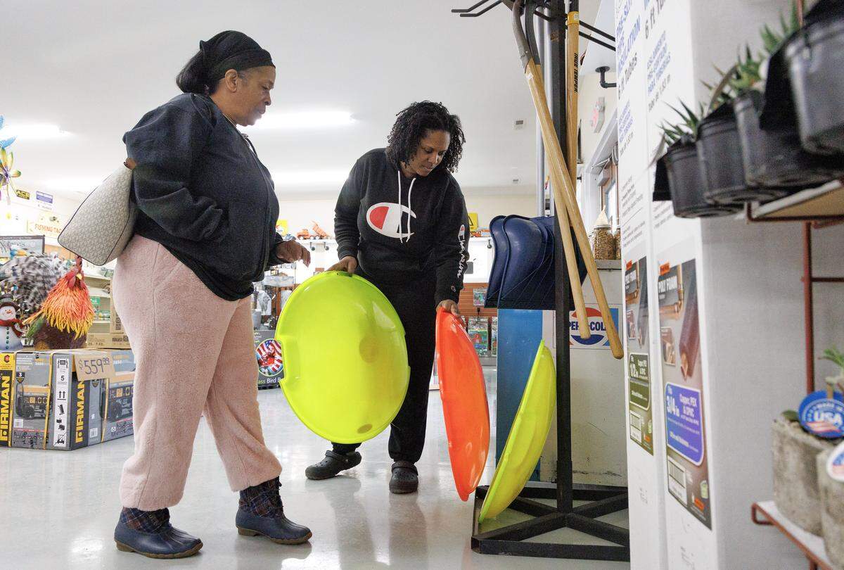 Teresa Jennings and Jamelia Parker look through sleds at Woods Farm & Garden in Hillsborough on Friday. 