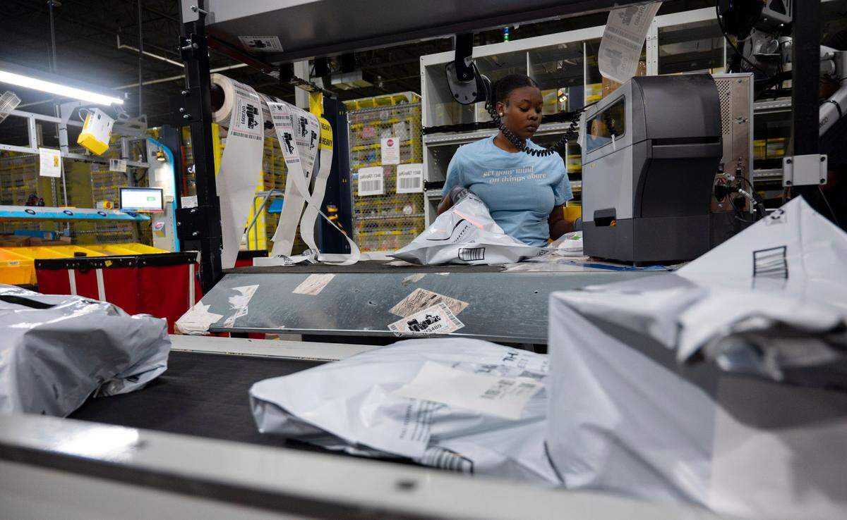 An Amazon worker packages items and labels them before they move onto a conveyor belt at the Same-Day Delivery Fulfillment Center in Durham on Wednesday, July 10, 2024.