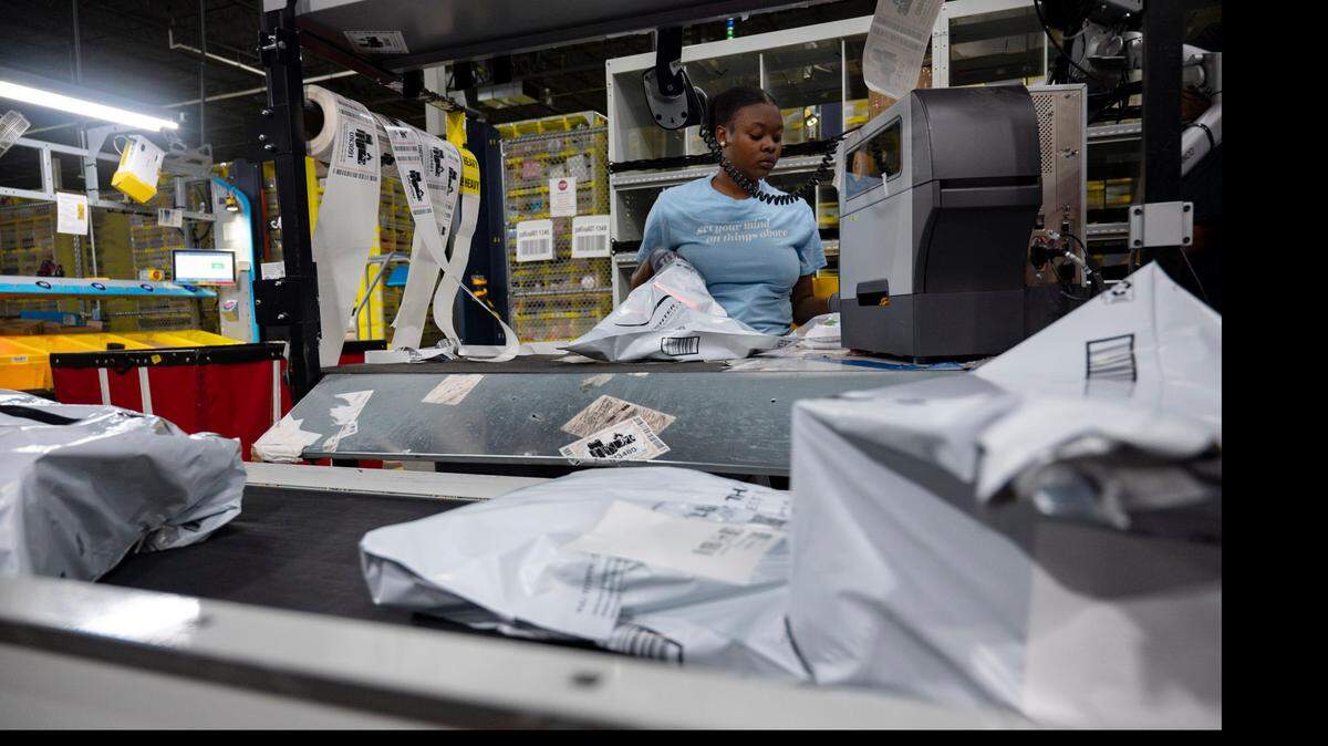 An amazon worker packages items and labels them before they move onto a conveyor belt at the Same-Day Delivery Fulfillment Center in Durham on Wednesday, July 10, 2024.
