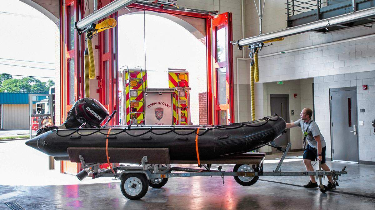 Cary Fire Department firefighter Jackson Ray pulls a swift water rescue boat up to a hitch as they prepare to depart for Kinston, NC, to assist with the response to Hurricane Dorian on Tuesday, Sept. 3, 2019, in Cary, NC.