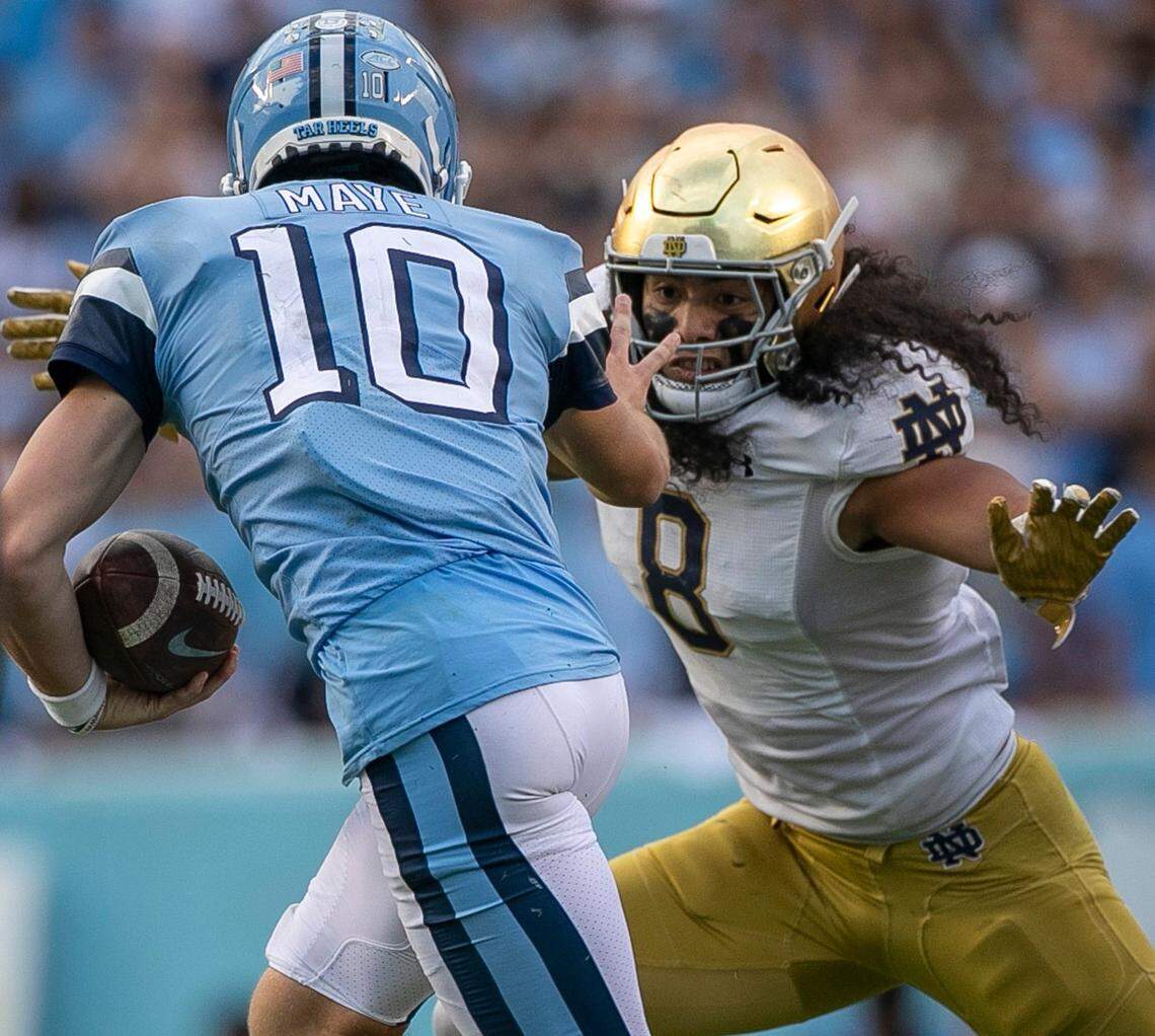 North Carolina quarterback Drake Maye (10) tries to escape the grasp of Notre Dame’s Isaiah Foskey (7) in the third quarter on Saturday, September 24, 2022 at Kenan Stadium in Chapel Hill, N.C.