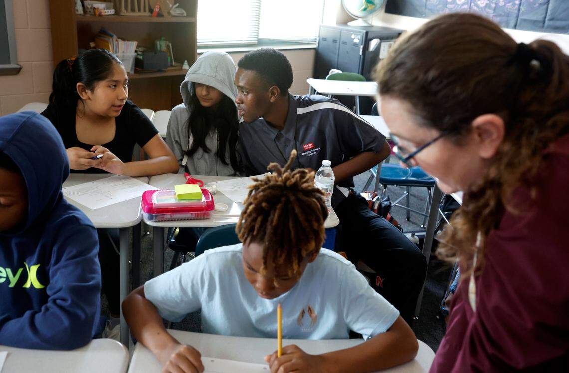 Jahzar Fields works with Perla Ramirez Urieta, left, and Alandra Gonzalez Alvarez while student teaching in Kerry Miquel’s 6th grade social studies class at Dillard Drive Magnet Middle School in Raleigh, N.C., Wednesday, Sept. 6, 2023.