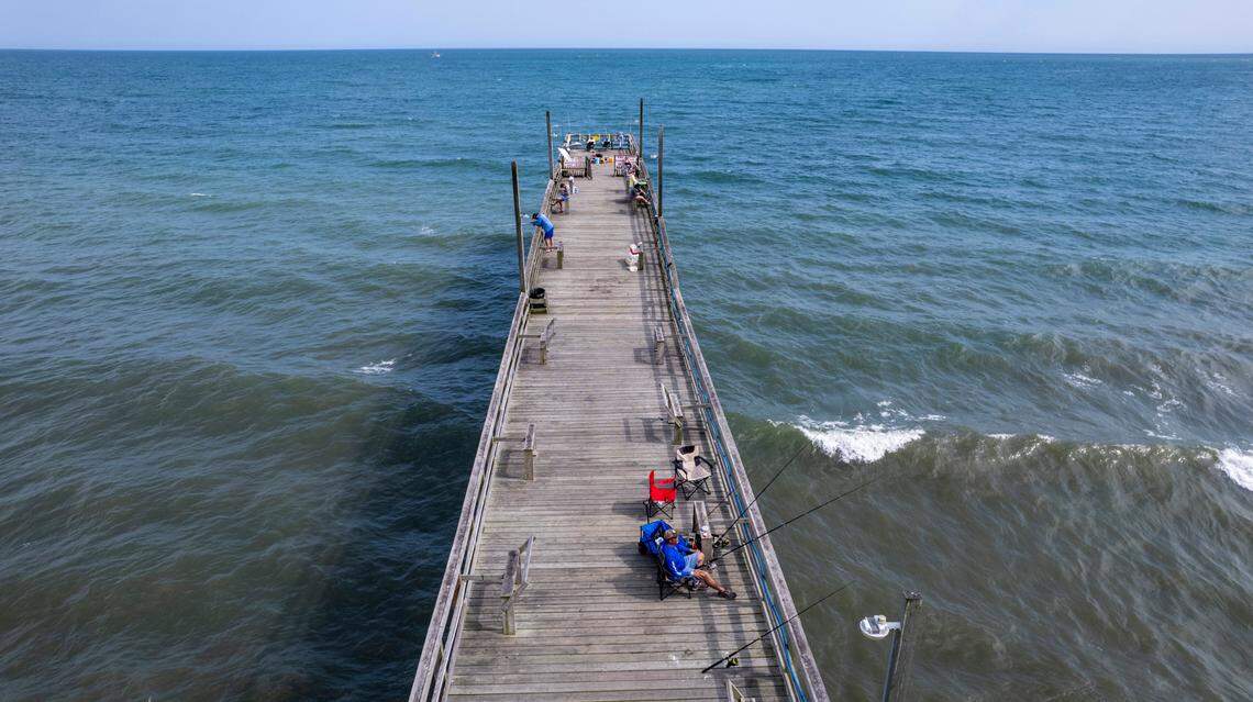Visitors fish on the Sunset Beach pier in June 2022.